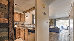 Una cocina moderna con armarios de madera, lavavajillas y una pared decorativa de piedra.