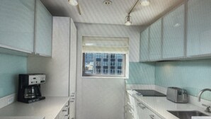 A compact kitchen with a coffee maker, toaster, and a window. - Cozy 1-bedroom condo with AC in peaceful New York.  For World Cup Soccer!! (New York)