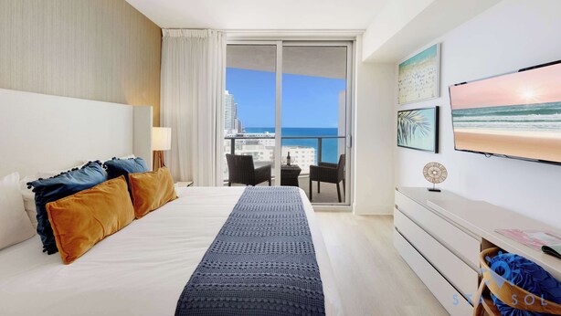 Habitació d'hotel amb un llit gran, un balcó amb vista al mar, televisió de pantalla plana i un aparcador.