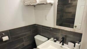 Un baño moderno con inodoro, lavamanos y toallero.