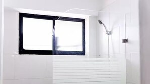 A bathroom with white tiles, a window, and a shower. - Spacious Central w/ Balcony + Kitchen - 2 Beds (Santo Domingo)