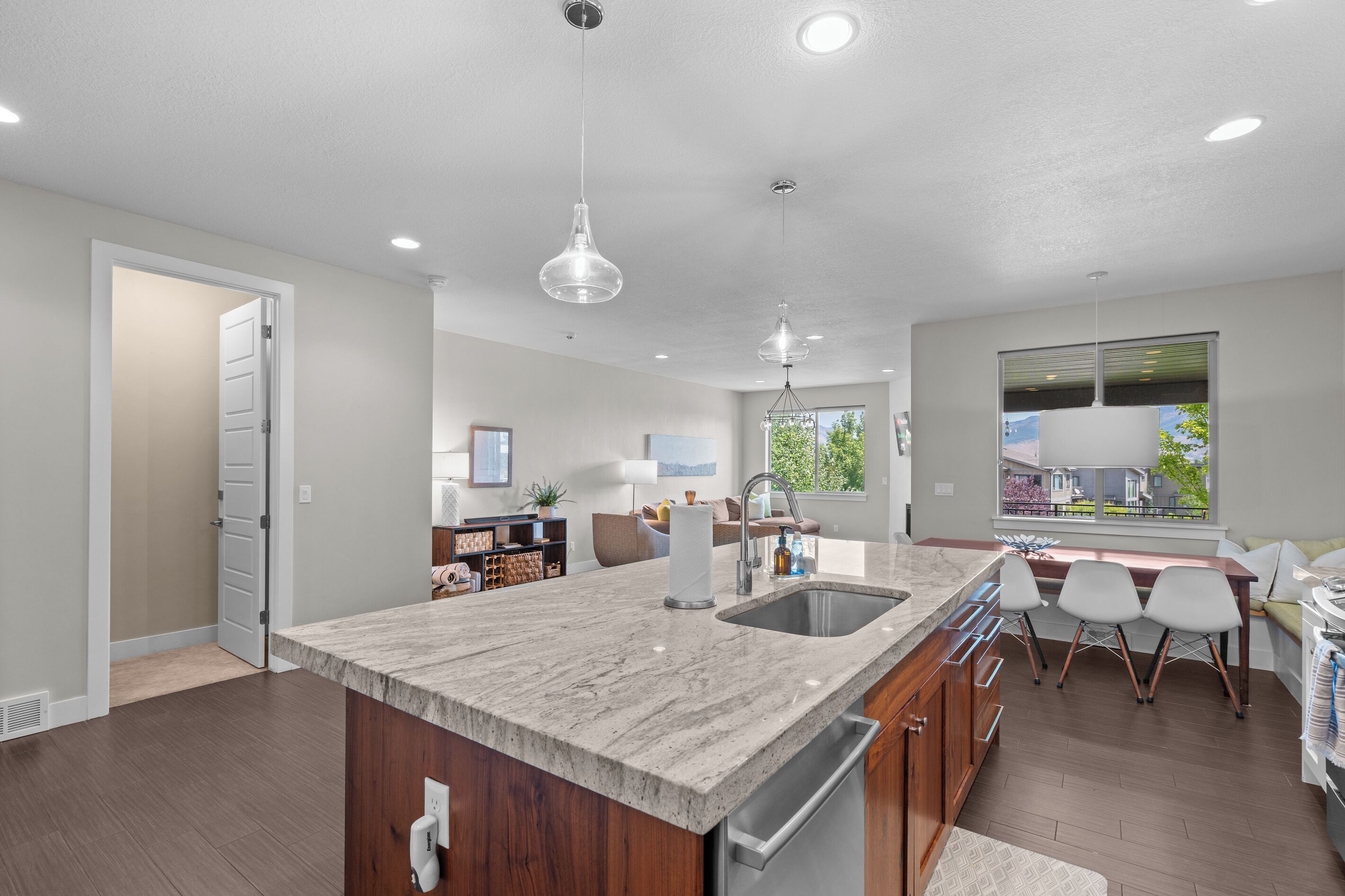 A modern kitchen with a large island, built-in appliances, and a view to the outside.
