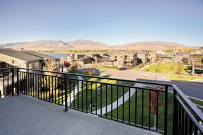 A residential area with modern houses, a clear sky, and mountains in the background. - Shred Reckoning | Pineview | Pool |  Hot Tub (Huntsville)