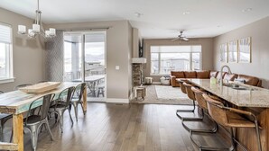 Et moderne køkken med en central ø, spiseplads med stole og udsigt udad.
