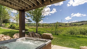 A hot tub under a wooden pergola with a view of a mountainous landscape. - Lakeside Getaway LS14A | Hot Tub | Dog-Friendly (Huntsville)