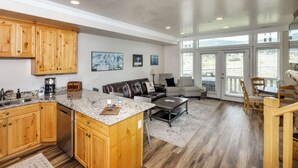 A spacious kitchen with wooden cabinets, a granite countertop, and a built-in dishwasher. - Lakeside Cove Retreat LS18|Hot Tub |Pool |Pineview (Huntsville)