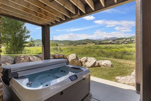 A hot tub under a wooden pergola with a view of a green landscape and mountains. - Pineview Lake Retreat LS22 | Hot Tub | Pool | Desk (Huntsville)