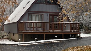 Eine Hütte mit einer großen Veranda, einem steilen Satteldach und der deutlich sichtbaren Nummer 6 an der Seite.