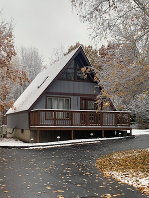 Eine Hütte mit einer großen Veranda, einem steilen Satteldach und der deutlich sichtbaren Nummer 6 an der Seite.