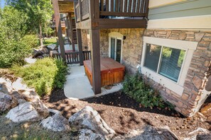 A stone house with a wooden deck, a hot tub, and a stone wall. - Paddle & Ski Retreat LS43 |Hot Tub |Pineview |Pool (Huntsville)