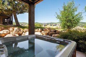 A hot tub with a clear view of a mountainous landscape and a wooden structure in the background. - Paddle & Ski Retreat LS43 |Hot Tub |Pineview |Pool (Huntsville)