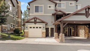 A multi-story residential building with a garage, stone accents, and a covered entryway. - Paddle & Ski Retreat LS43A |Pool |Hot Tub|Pineview (Huntsville)