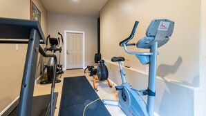 A home gym with a treadmill, elliptical, and stationary bike. - Mountain Pass Retreat LS54 | Hot Tub| Lakefront (Huntsville)