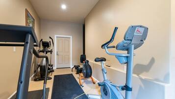 A home gym with a treadmill, elliptical, and stationary bike.
