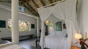A room with a canopy bed, a bench, and a table with a lamp. - Vereda Yelapa: Passion Fruit (Yelapa)