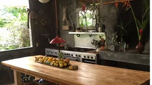 A kitchen with a wooden table, fruit, and various kitchen utensils. - Vereda Yelapa: Passion Fruit (Yelapa)