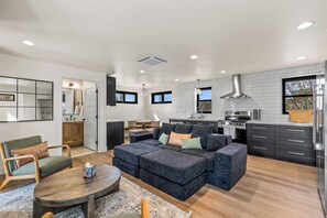 A modern kitchen with a stove, oven, and dining area. - Epic Rooftop Views - Luxury DT FLAG - 2 King Beds (Flagstaff)