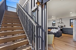 A modern interior with a staircase, a kitchen, and a living area. - Epic Rooftop Views - Luxury DT FLAG - 2 King Beds (Flagstaff)