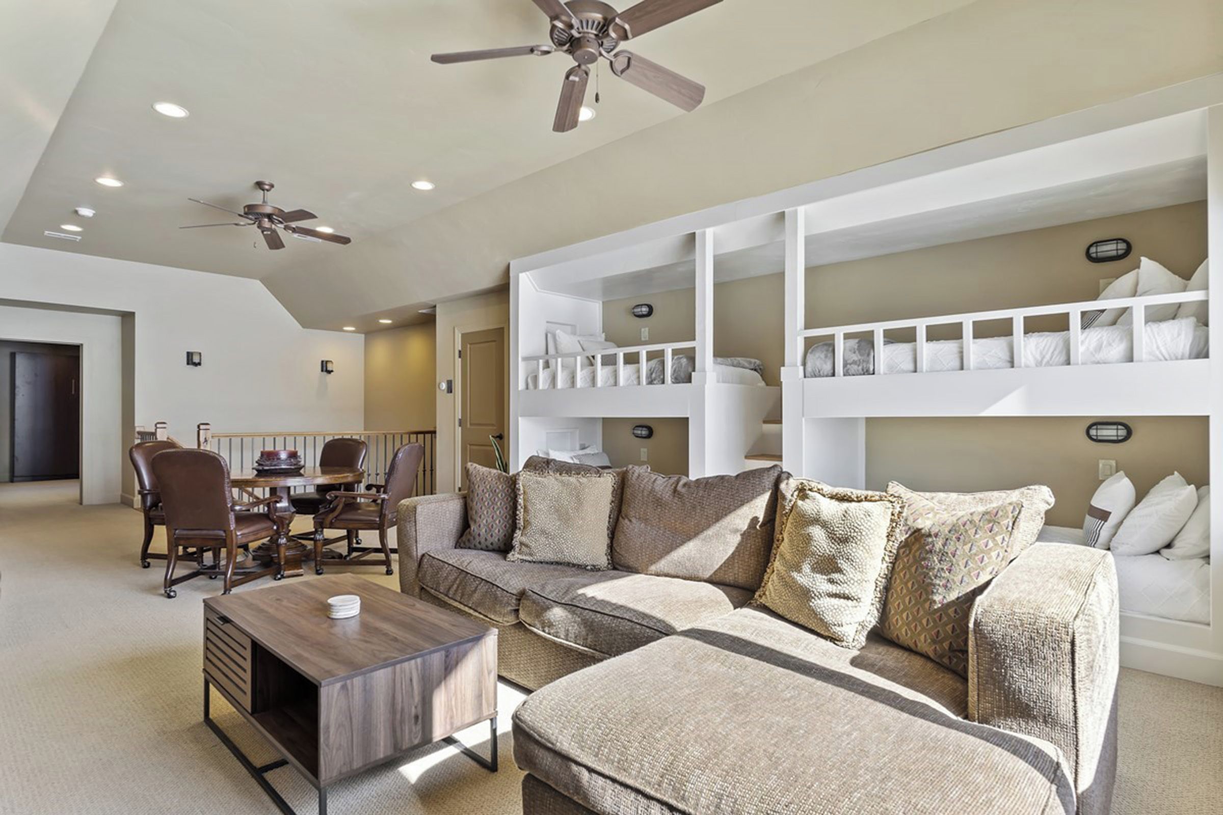 A living room with a sofa, coffee table, and bunk beds.