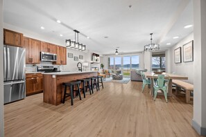 Een moderne keuken met houten kastjes, roestvrijstalen apparatuur en een centraal eiland met krukken.