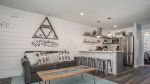 Une cuisine moderne dotée d’un îlot central, de tabourets de bar et d’un réfrigérateur.