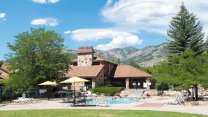 Un complexe hôtelier doté d’une piscine, d’un espace extérieur aménagé et offrant une vue sur les montagnes.