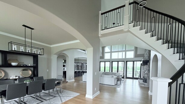 A spacious living area with a staircase, dining area, and kitchen.