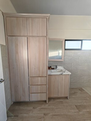 Ein Badezimmer mit einem Holzbadezimmer, einem Spiegel und einem Fenster.