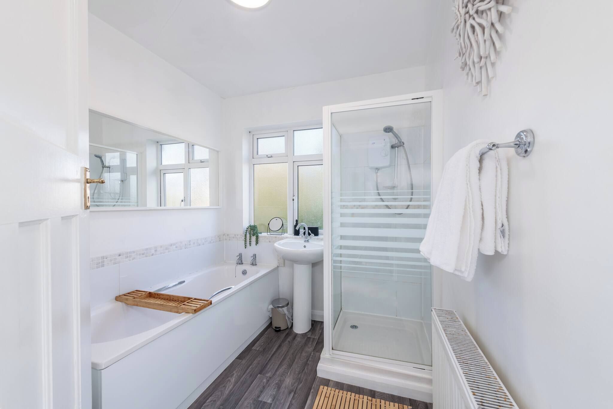 Un baño moderno con bañera, lavamanos y ducha envuelta en vidrio.