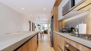 Une cuisine moderne avec des meubles en bois, des appareils en acier inoxydable et un four à micro-ondes encastré.