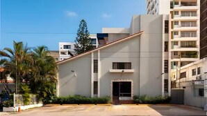 Un bâtiment moderne doté d’un toit plat, d’une entrée centrale et d’un parking situé à l’avant.