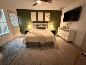 A bedroom with a bed, nightstands, a dresser, a ceiling fan, and artwork on the wall. - EaDo Treasure with Private Garage Near Downtown and Stadiums (Houston)