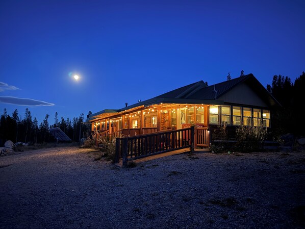 A lodge with a wooden exterior, a covered porch, and a gravel driveway.