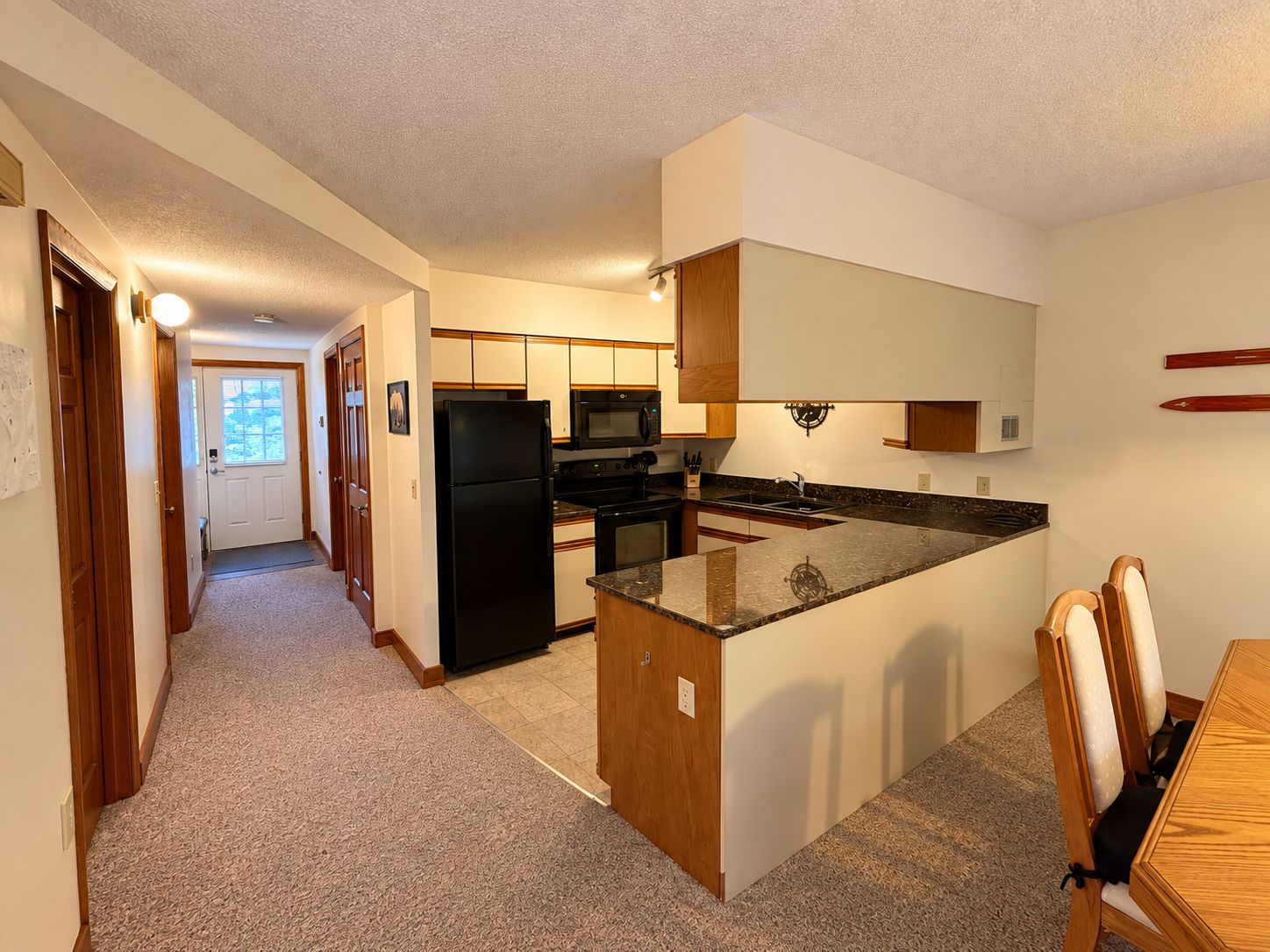 A compact kitchen with a central island, a microwave, a refrigerator, and a sink.