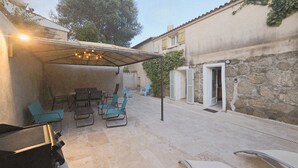 An outdoor patio area with a covered seating arrangement and a grill. - CASA FOCI -  maison T3 (Sainte Lucie de Porto Vecchio)