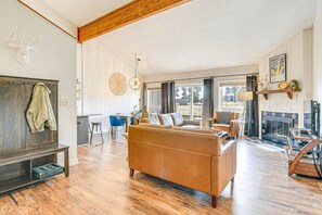 Ein geräumiges Wohnzimmer mit einer großen Couch, einem Kamin und einem Essbereich mit Tisch und Stühlen.