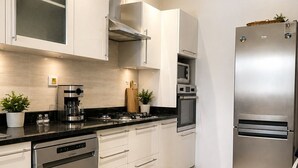 A modern kitchen with stainless steel appliances, white cabinetry, and a dishwasher. - Luxury Oasis S 2 Comfort at the Garden in Carthage (Tunis)