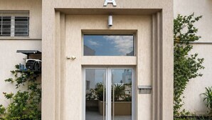 A building entrance with a large 'A' sign, a glass door, and a small window above. - Luxury Oasis S 2 Comfort at the Garden in Carthage (Tunis)