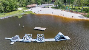 Vue aérienne d’un parc au bord d’un lac, avec un quai, des aires de pique-nique et des jeux pour enfants.