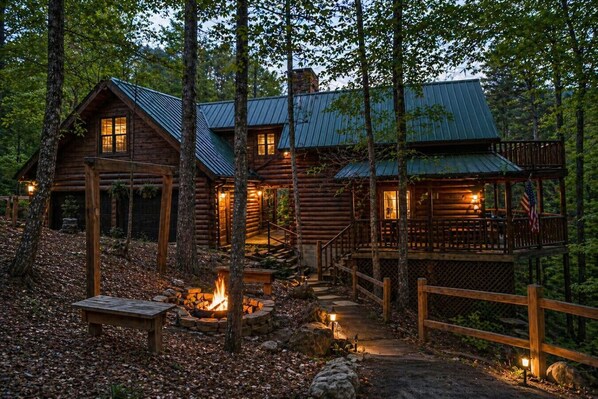 A log cabin with a fire pit, wooden deck, and a covered porch. - Rustic Pet Friendly Cabin in Pigeon Forge! (Pigeon Forge)
