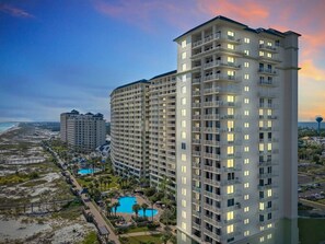 Un hôtel de grande hauteur doté de nombreux balcons, d’une piscine et offrant une vue sur la plage.