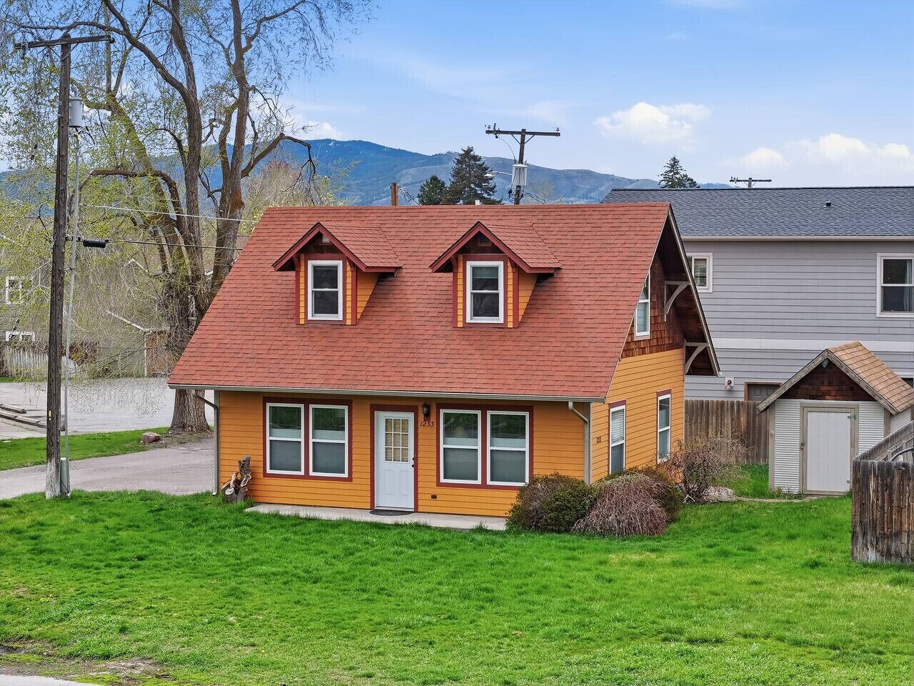 A two-story house with a red roof, a front porch, and a garage.
