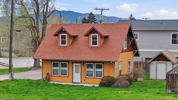 A two-story house with a red roof, a front porch, and a garage.