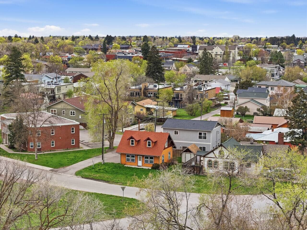 Un quartier résidentiel avec des maisons, un ciel dégagé et des arbres.
