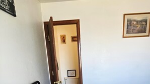 Ein Schlafzimmer mit einem Bett, einer Tür zu einem Badezimmer und einem gerahmten Bild an der Wand.