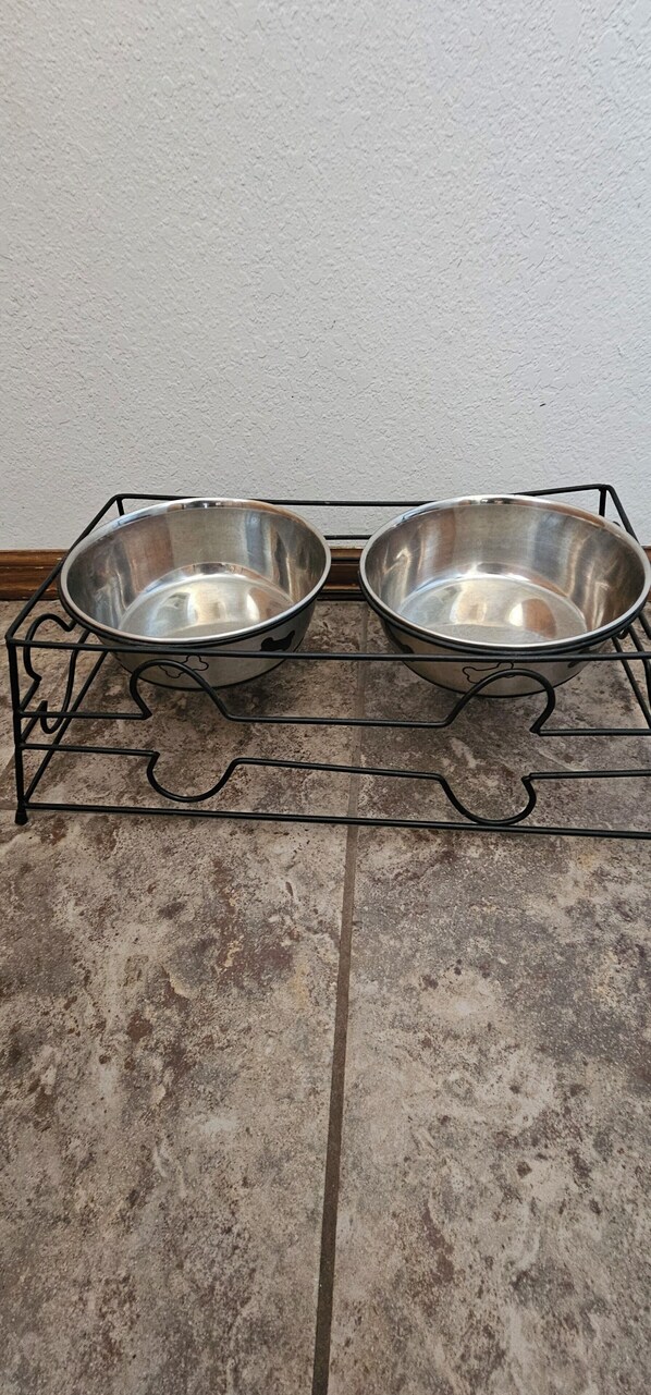 Twee roestvrijstalen kommen op een metalen rek.