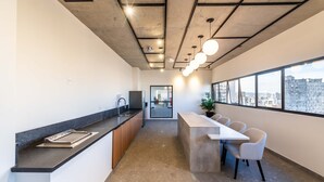 Una cocina moderna con una encimera amplia, un fregadero y un comedor con sillas y una mesa.