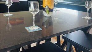 A modern kitchen with a dining table, chairs, and a vase with flowers. - Villa Vonu - 2 Bedroom Ensuit. Your own pool, secured landscape near the beach. (Pacific Harbour)