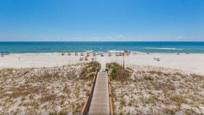 A beach with a wooden boardwalk leading to the shore, sandy beach, and ocean. - Windemere 1103 | Beachfront | Seasonally Heated Pool | My Beach Getaways (Pensacola)