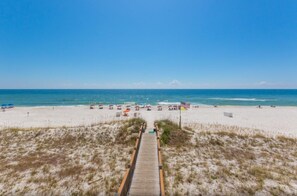 A beach with a wooden boardwalk leading to the shore, sandy beach, and ocean. - Windemere 1103 | Beachfront | Seasonally Heated Pool | My Beach Getaways (Pensacola)